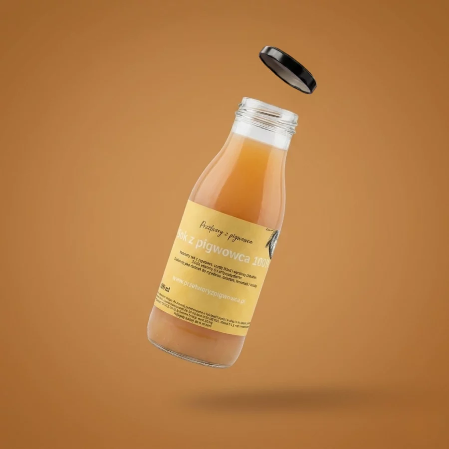 Butelka z sokiem pigwowcowym 100% na tle brązowym, wieczko unosi się obok. Naturalny napój owocowy.
