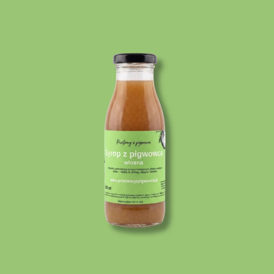 Syrop z pigwowca w butelce na zielonym tle, naturalny i aromatyczny, idealny do herbaty i deserów.
