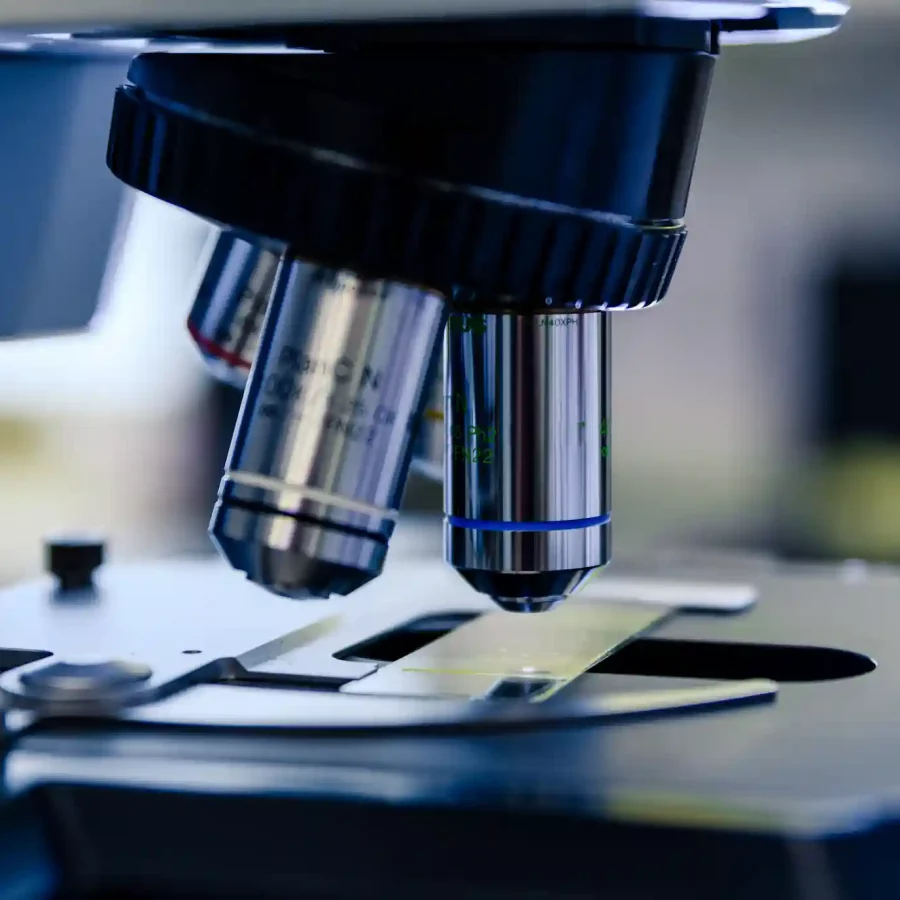 Zbliżenie na soczewki mikroskopu w laboratorium naukowym, ostrość na detale optyczne.
